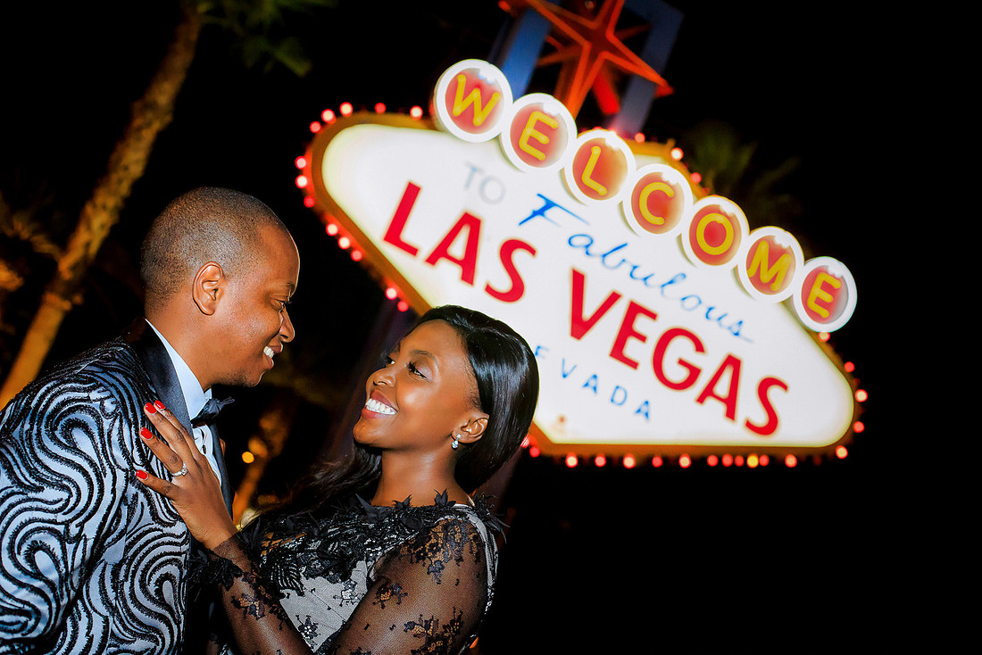 Couple embracing during an anniversary photo shoot at the Welcome to Fabulous Las Vegas Sign.