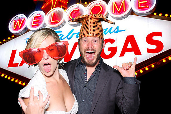 Guests posing in a photo booth with props at a Las Vegas event