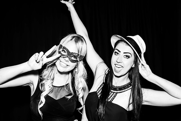 Guests posing in a photo booth with props at a Las Vegas event