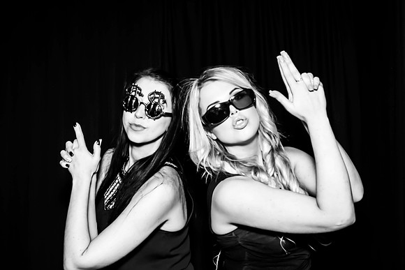 Guests posing in a photo booth with props at a Las Vegas event