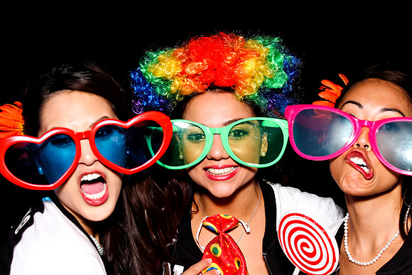 Guests posing in a photo booth with props at a Las Vegas event