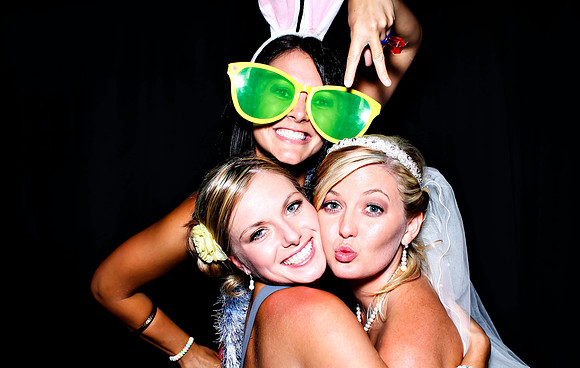 Guests posing in a photo booth with props at a Las Vegas event